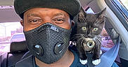 Luna is registered to the contest to win money with this photo: animal, backseat, black_and_white_cat, black_cap, car, cat_tag, daylight, face, human, indoor, kitten, looking, man, mask, pet, portrait, seatbelt, shoulder, sitting, window