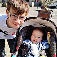 Swan a rejoint le concours — aidez-le/la à gagner de superbes lots ! baby, car, child, clothing, face, glasses, happy, infant, jacket, outdoor, pavement, person, planter, portrait, sibling, smile, stroller, sunlight, tree, urban
