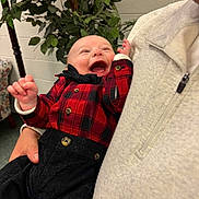 Anthony joined the competition — help win amazing prizes! adult_hand, baby, black_pants, bow_tie, child, clothing, cute, face, green_leaves, happy, holding, indoor, joyful, laughing, light_gray_sweater, person, plaid_shirt, plant, portrait, smiling