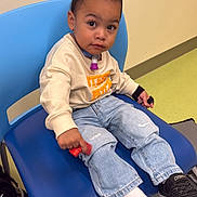 Israel joined the competition — help win amazing prizes! child, toddler, baby, portrait, sitting, chair, blue_chair, waiting_room, indoor, smiling, serious_expression, face, eyes, clothing, sweatshirt, jeans, sneakers, toy, colorful_floor, casual_fashion