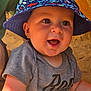 baby, child, smiling, hat, bucket_hat, blue_hat, shirt, grey_shirt, face, happy, outdoor, sunlight, sand, closeup, cute, infant, person, summer, joy, portrait