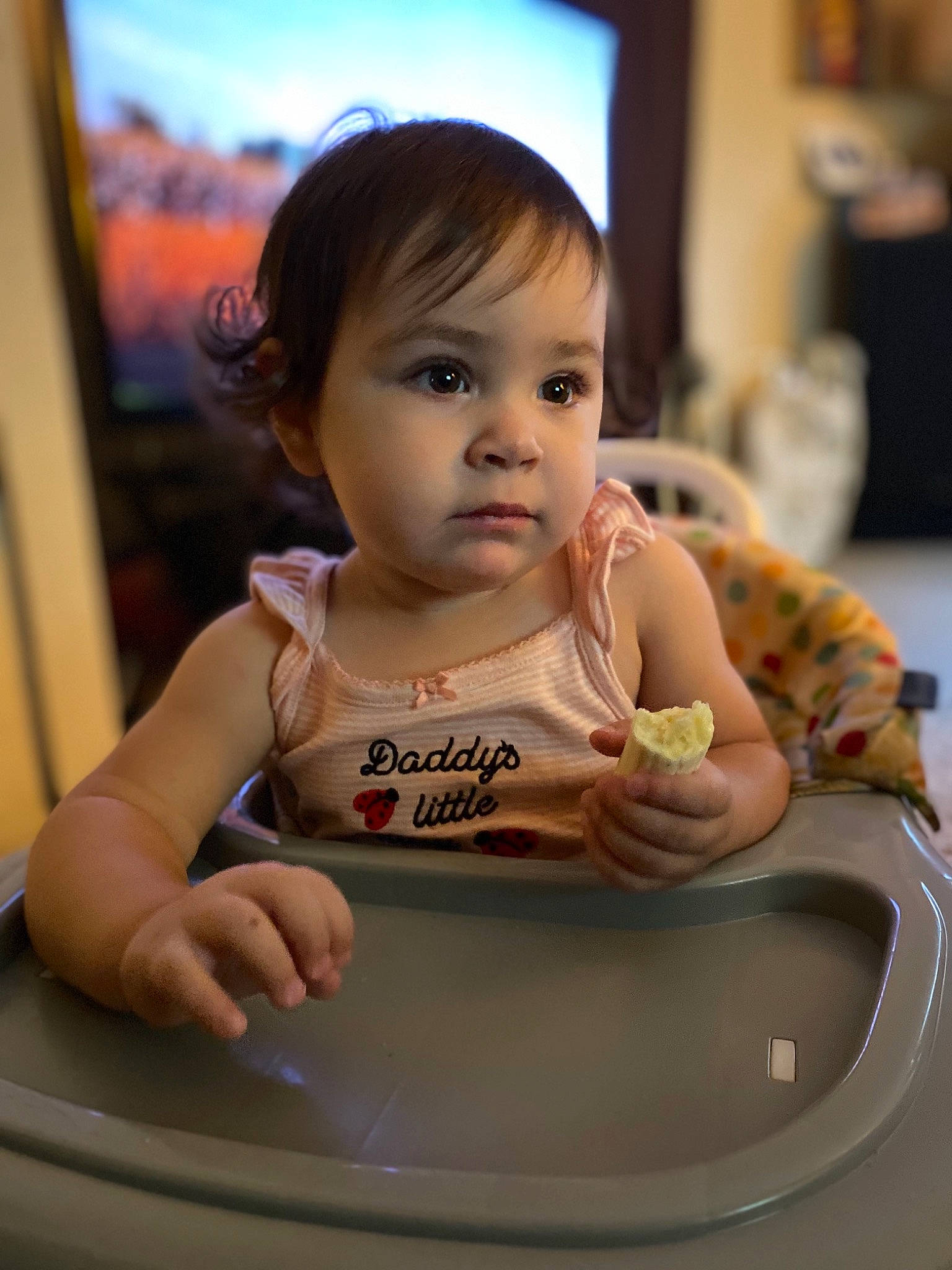 Lily is registered to the contest to win money with this photo: baby, beauty, bib, cheek, child, chin, dishware, drinkware, electronic_device, finger, fun, hairstyle, happy, person, picture_frame, room, serveware, sitting, skin, tableware