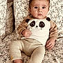 baby, bed, child, cozy, cute, expression, eyes, face, floral_pattern, foot, hand, indoors, infant, knitted_pants, panda_print, person, pillow, portrait, soft_lighting, sweatshirt