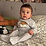 Tom participe au concours pour gagner de l'argent avec cette photo : adult, baby, bed, bedspread, child, curious, cute, floral, fox_patch, hand, headboard, home, indoors, infant, pajamas, person, portrait, sitting, soft_lighting, wallpaper