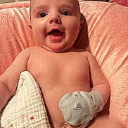 Cassandra Mosier joined the competition — help win amazing prizes! baby, infant, smiling, blanket, mitten, cushion, pink, skin, happy, face, mouth_open, lying_down, child, young, indoors, soft_texture, closeup, cute, person, comfort