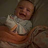 Cassandra Mosier is registered to the contest to win money with this photo: baby, blanket, bed, child, cozy, cute, dressed, face, happy, infant, indoors, laying, light, pajamas, person, portrait, smile, soft, toddler, warm