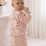 Phoebe a rejoint le concours — aidez-le/la à gagner de superbes lots ! toddler, child, pink_pajamas, indoor, furniture, dresser, curly_hair, blond_hair, blue_eyes, baby, soft_lighting, cozy_room, carpet, flowers, vase, portrait, standing, cute, home, cute_expression