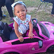 Paislee joined the competition — help win amazing prizes! baby, child, toddler, smiling, portrait, toy_car, pink_car, outdoor, garden, grass, bow, dress, cherries, steering_wheel, playtime, vehicle, sitting, standing, adults, happy