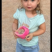 Julia a rejoint le concours — aidez-le/la à gagner de superbes lots ! toddler, child, outdoor, gravel, rocks, pink_container, shorts, tshirt, curly_hair, standing, sneakers, casual_clothing, young_child, cute, playful, daylight, looking_at_camera, person, nature, summer