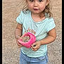 toddler, child, outdoor, gravel, rocks, pink_container, shorts, tshirt, curly_hair, standing, sneakers, casual_clothing, young_child, cute, playful, daylight, looking_at_camera, person, nature, summer