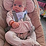 baby, baby_seat, bib, bracelet, carpet, child, clothing, comfort, curious, cushion, expression, face, footwear, hand, indoors, infant, pajamas, person, seated, straps