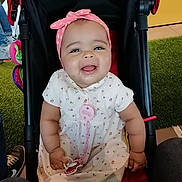 Kélya participe au concours pour gagner de l'argent avec cette photo : baby, child, stroller, smiling, headband, dress, pacifier, indoor, carpet, person, happy, cute, infant, sitting, clothing, footwear, hand, toy, background, people