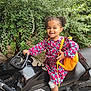 Kélya participe au concours pour gagner de l'argent avec cette photo : child, girl, motorcycle, kawasaki, black_motorcycle, yellow_backpack, curly_hair, pigtails, smiling, outdoor, greenery, dress, footwear, white_shoes, socks, bandage, happy, person, playful, nature
