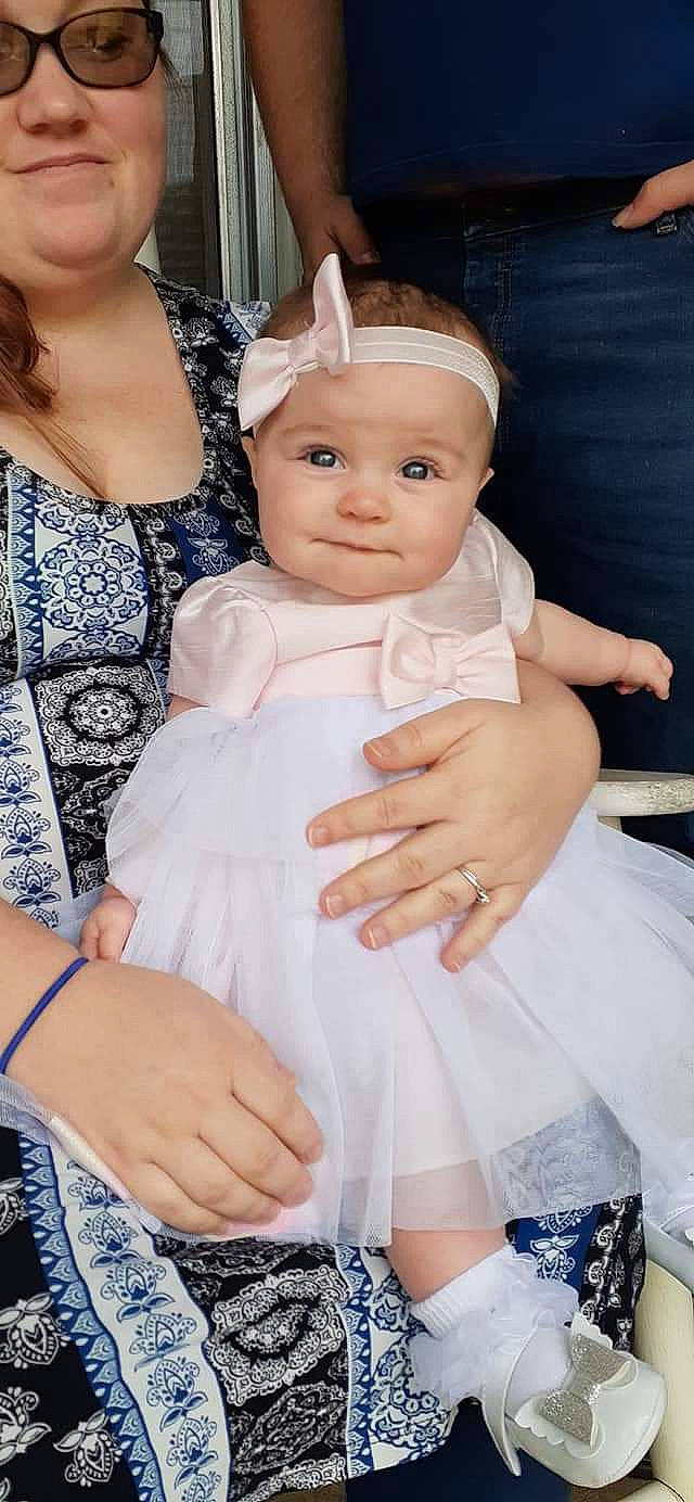 Alannah is registered to the contest to win money with this photo: baby, child, child_model, dress, finger, gesture, hair_accessory, hand, headwear, person, toddler