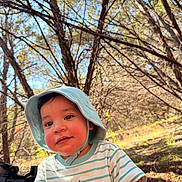 Lorenzo is registered to the contest to win money with this photo: toddler, child, baby, hat, bucket_hat, striped_shirt, tiger_design, outdoor, forest, trees, sunlight, nature, happy, smiling, young_child, daylight, person, cute, exploring, playful