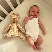 Margot joined the competition — help win amazing prizes! baby, crib, plush_toy, giraffe, white_onesie, infant, smile, hand, foot, bed, soft_toy, happy, child, cute, sleeping_area, furniture, face, skin, newborn, indoors