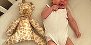Margot joined the competition — help win amazing prizes! baby, bed, child, crib, cute, face, foot, furniture, giraffe, hand, happy, indoors, infant, newborn, plush_toy, skin, sleeping_area, smile, soft_toy, white_onesie