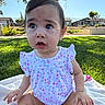 baby, child, infant, outdoor, grass, blanket, sunlight, onesie, floral_pattern, curious_expression, sitting, park, tree, daylight, greenery, cute, young_child, nature, summer, portrait