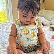 Madison is registered to the contest to win money with this photo: baby, child, infant, sitting, bed, window, natural_light, pigtails, playful_hair, cute, smiling, socks, clothing, patterned_outfit, indoor, soft_light, skin, hand, fingers, expression