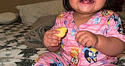 Madison joined the competition — help win amazing prizes! toddler, child, smiling, pajamas, indoor, bed, blanket, fruit, pineapple, happy, cute, sitting, person, clothing, face, sock, hair, skin, room, cozy