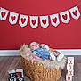 baby, infant, basket, fur_blanket, denim_overalls, white_shoes, heart_bunting, red_background, wooden_floor, love_blocks, wooden_blocks, pink_petals, valentine_theme, studio_photo, portrait, props, flooring, cute, newborn, lying_down