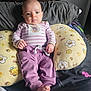 baby, infant, child, pillow, boppy_pillow, onesie, striped_clothing, purple_pants, tiny_toes, hands, face, eyes, bed, blanket, cute, indoor, portrait, furniture, nursery, relaxed