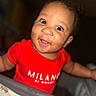 Kairo is registered to the contest to win money with this photo: baby, child, smiling, red_shirt, face, portrait, indoor, cute, happy, infant, person, closeup, eyes, baby_clothing, playpen, baby_toy, skin, expression, head, funny_face