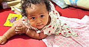Lanayah-La'Raa joined the competition — help win amazing prizes! baby, curly_hair, red_surface, dress, strawberry_pattern, blanket, laptop, indoor, child, cute, gaze, expression, infant, lying_down, homely, soft_lighting, portrait, closeup, comfortable, cozy