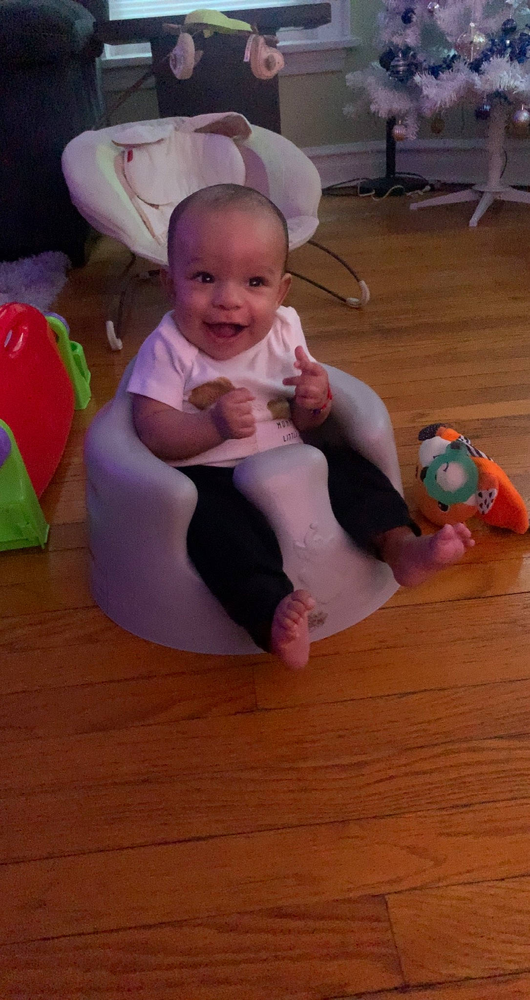Noel is registered to the contest to win money with this photo: baby, baby_toddler_clothing, cheek, child, comfort, flooring, foot, fun, happy, hardwood, hat, head, human_leg, person, pink, sitting, skin, smile, sock, toddler