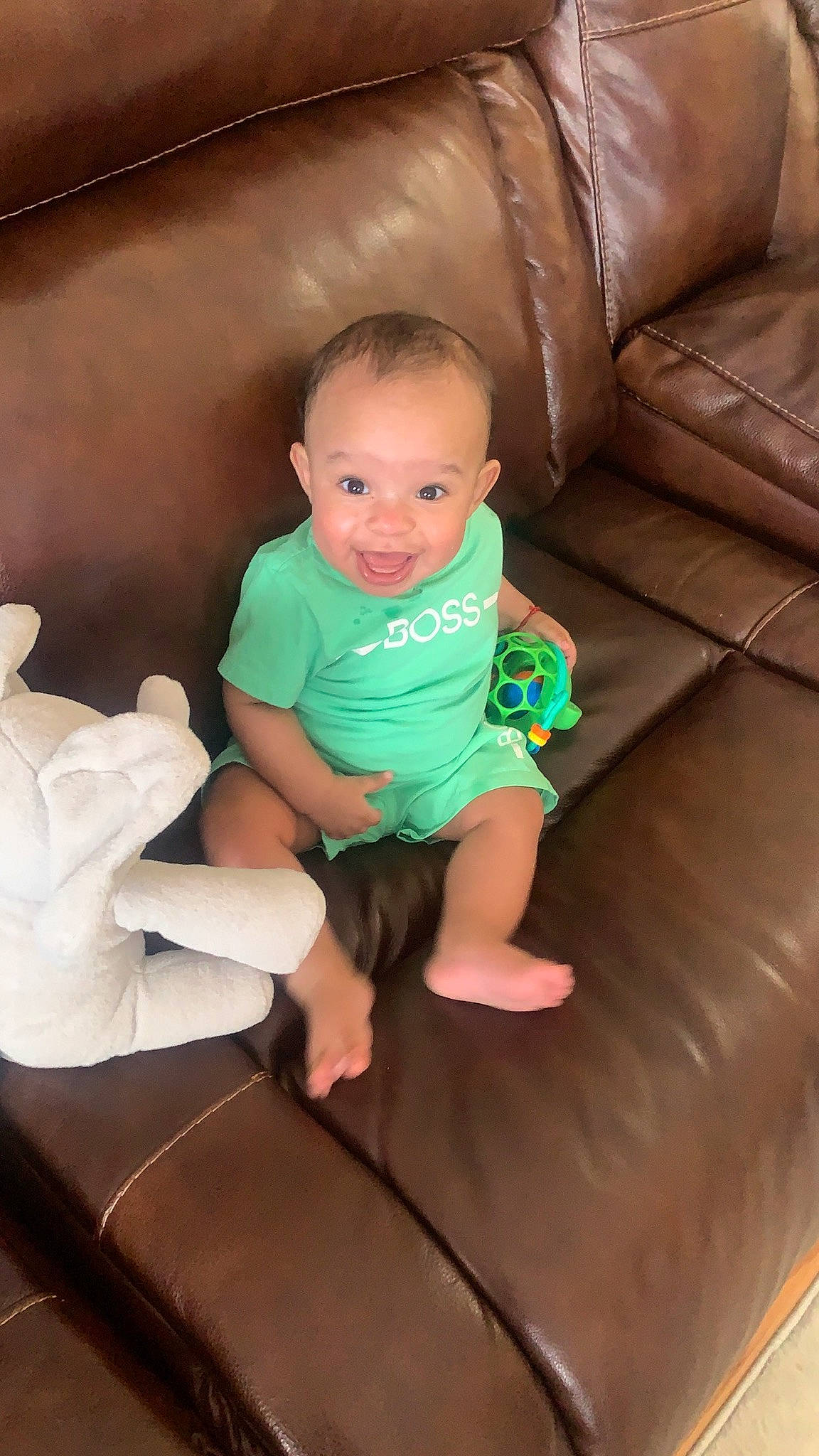 Amir is registered to the contest to win money with this photo: baby, baby_toddler_clothing, cheek, child, comfort, couch, floor, flooring, foot, fun, human_leg, joy, knee, leg, person, room, shorts, sitting, sock, t_shirt