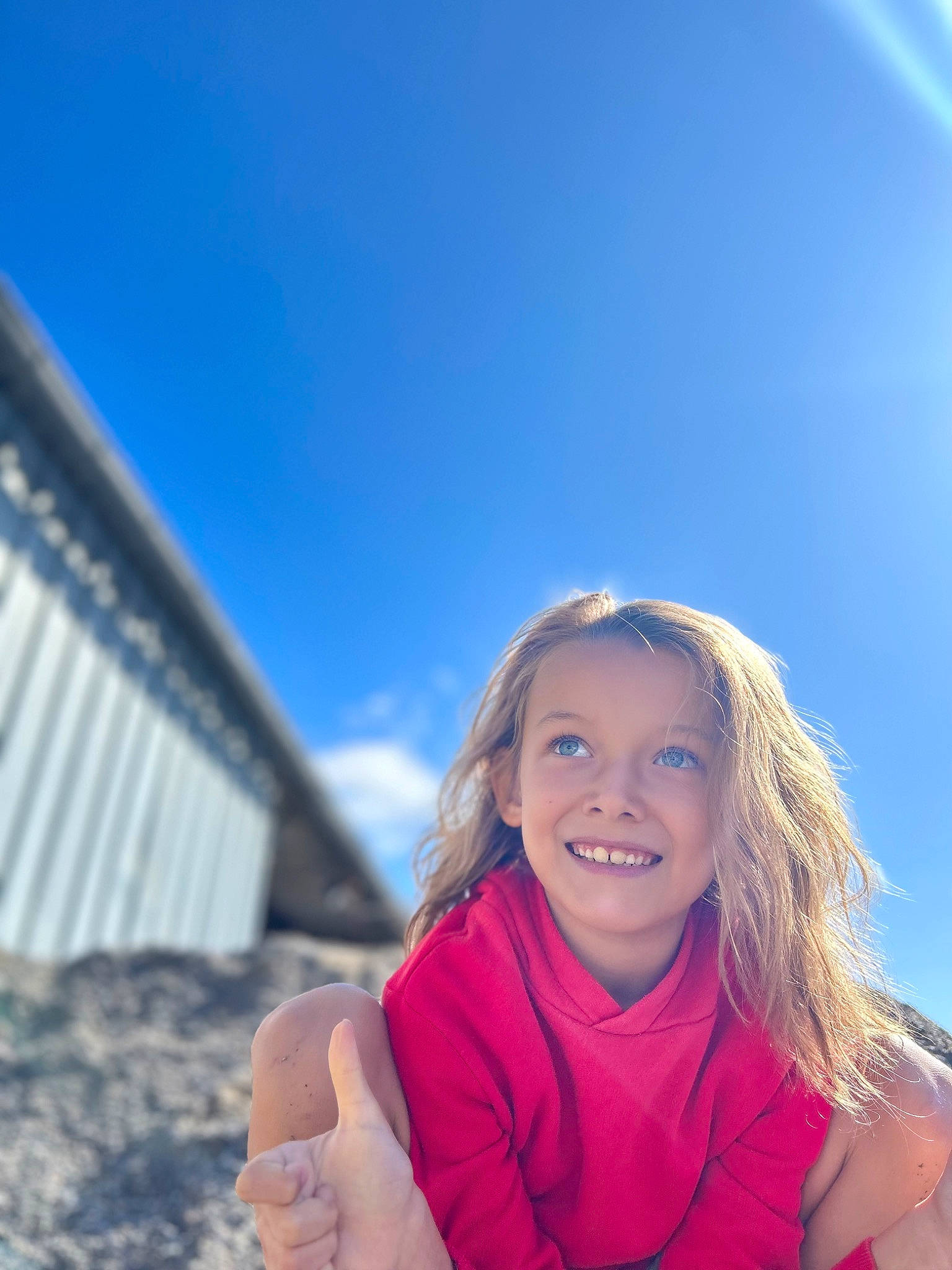 Tiago a rejoint le concours — aidez-le/la à gagner de superbes lots ! cloud, electric_blue, flash_photography, fun, gesture, grass, hand, happy, joy, laugh, leisure, long_hair, ocean, people_in_nature, person, recreation, sitting, sky, smile, toddler