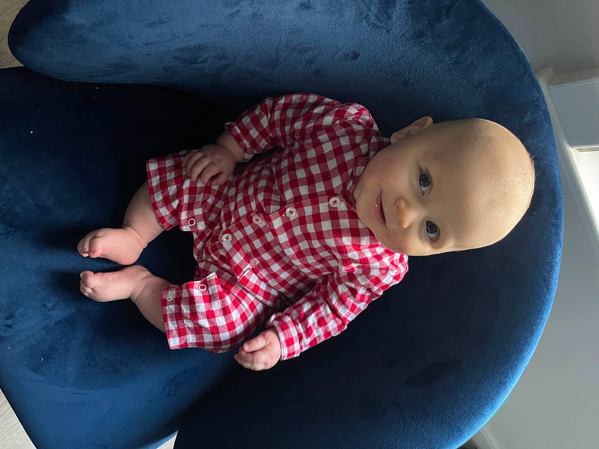 Cian is registered to the contest to win money with this photo: arm, baby, baby_products, baby_toddler_clothing, carmine, child, comfort, elbow, finger, knee, linens, mouth, nose, pattern, person, plaid, sitting, skin, sleeve, textile