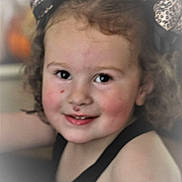 Ila joined the competition — help win amazing prizes! child, toddler, face, smile, curly_hair, headband, leopard_print, rosy_cheeks, black_top, portrait, cute, happy, indoor, closeup, person, young_child, expression, skin, hair_accessory, childhood