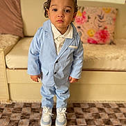 Chris a rejoint le concours — aidez-le/la à gagner de superbes lots ! toddler, child, boy, suit, blue_suit, white_shirt, sneakers, carpet, couch, pillow, indoor, portrait, standing, serious, cute, fashion, young_child, person, home, furniture