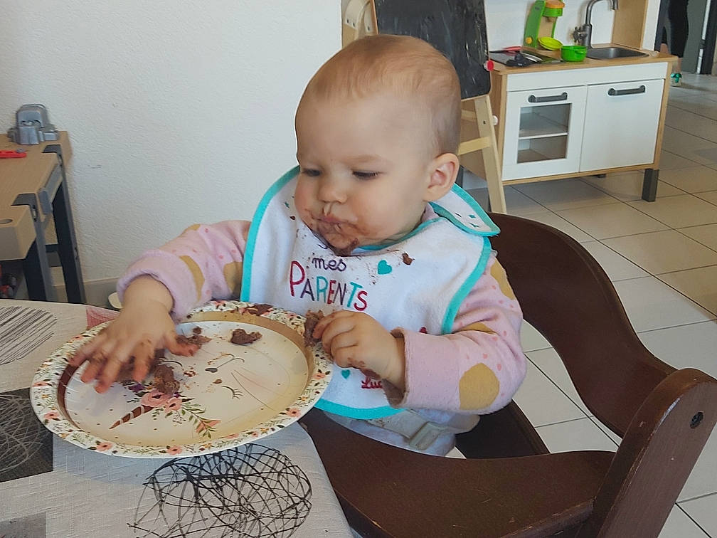 Anna a rejoint le concours — aidez-le/la à gagner de superbes lots ! baby, baby_toddler_clothing, blurred, cabinetry, cake, chair, cuisine, dish, dishware, food, fork, furniture, kitchen_utensil, person, plate, platter, porcelain, serveware, spoon, table