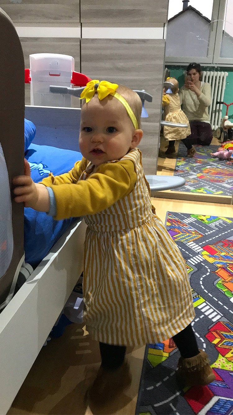 Anna participe au concours pour gagner de l'argent avec cette photo : baby, boot, chair, child, costume, event, fashion_design, flooring, fun, leisure, pattern, person, play, room, sandal, standing, textile, toddler, toy, vacation