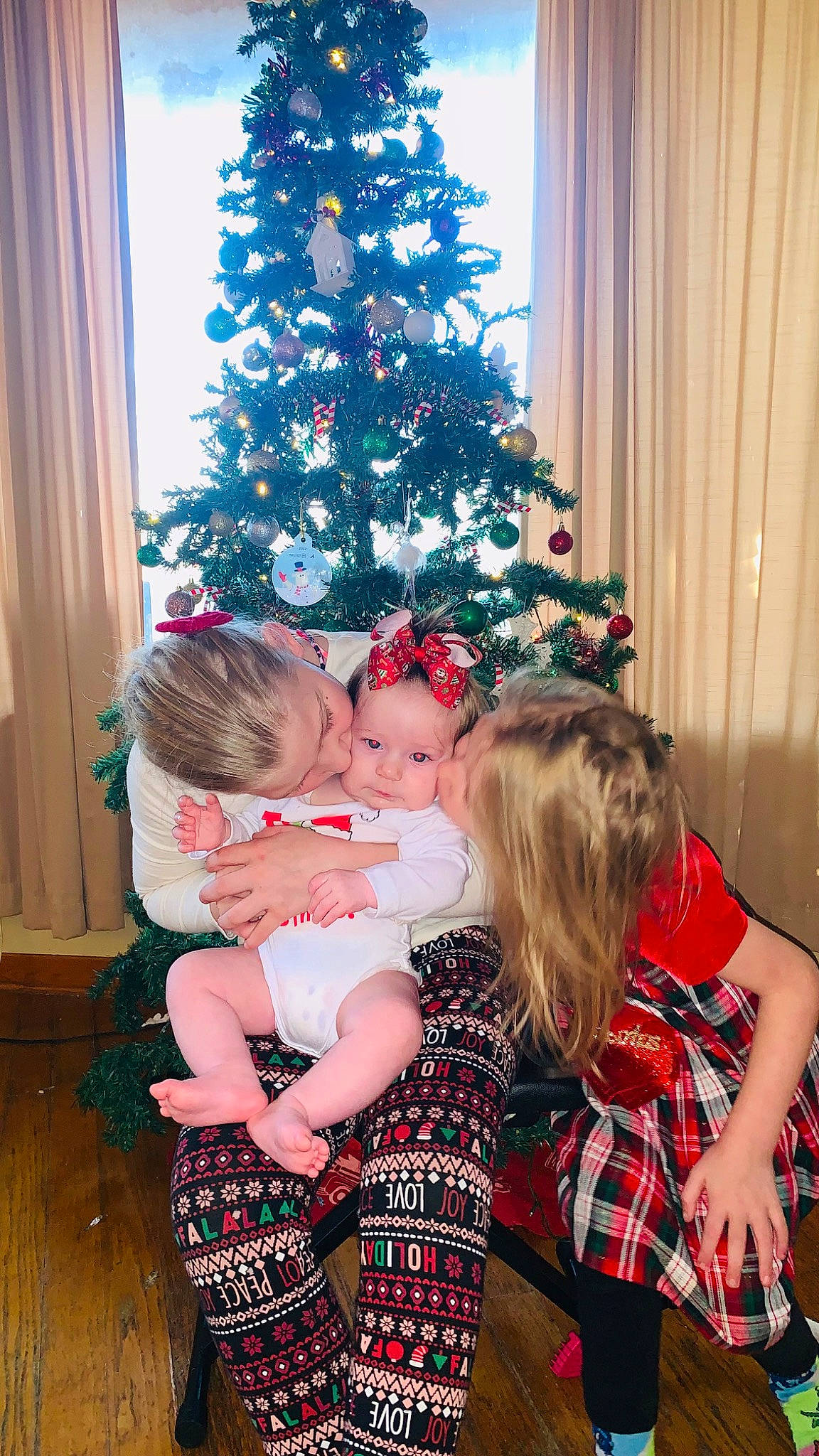 Hazel joined the competition — help win amazing prizes! christmas_decoration, christmas_ornament, christmas_tree, comfort, couch, curtain, fun, happy, headwear, holiday_ornament, interior_design, lap, ornament, people, person, plant, red, standing, tartan, toddler