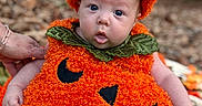 Gabriel is registered to the contest to win money with this photo: baby, child, infant, pumpkin_costume, halloween, autumn, outdoor, forest, leaves, orange, costume, hat, jack_o_lantern, sitting, blanket, portrait, blue_eyes, wide_eyed, smiling, seasonal