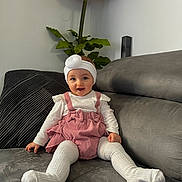 Soléa a rejoint le concours — aidez-le/la à gagner de superbes lots ! baby, child, clothing, couch, cute, decor, flower, furniture, happy, headband, home, indoor, person, pink_overalls, plant, portrait, sitting, smiling, toddler, white_tights