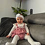 baby, child, clothing, couch, cute, decor, flower, furniture, happy, headband, home, indoor, person, pink_overalls, plant, portrait, sitting, smiling, toddler, white_tights
