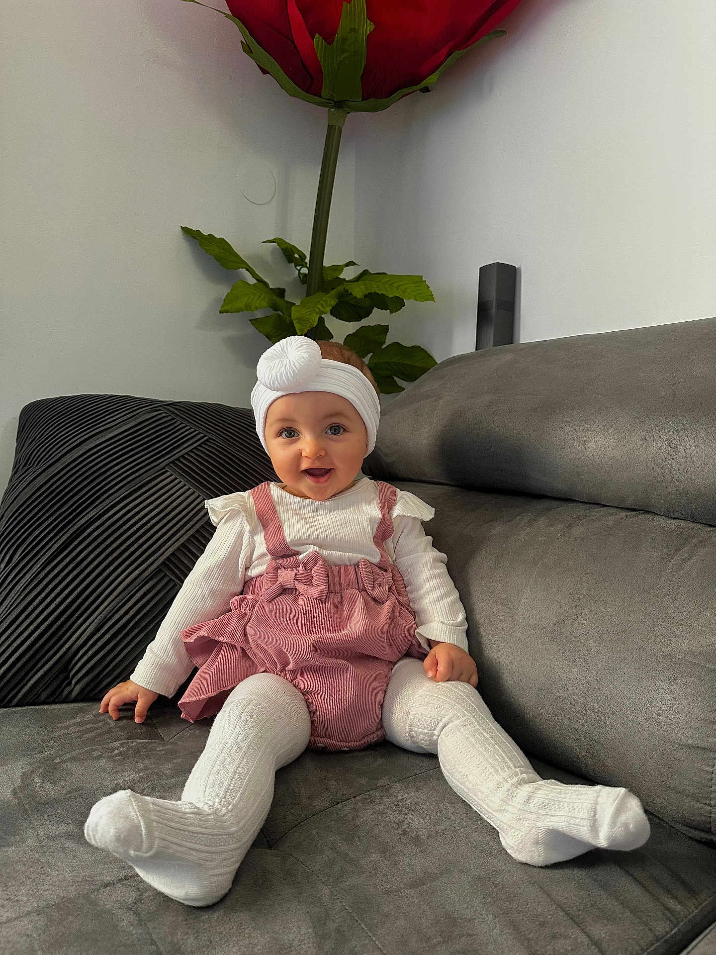 Soléa a rejoint le concours — aidez-le/la à gagner de superbes lots ! baby, child, clothing, couch, cute, decor, flower, furniture, happy, headband, home, indoor, person, pink_overalls, plant, portrait, sitting, smiling, toddler, white_tights