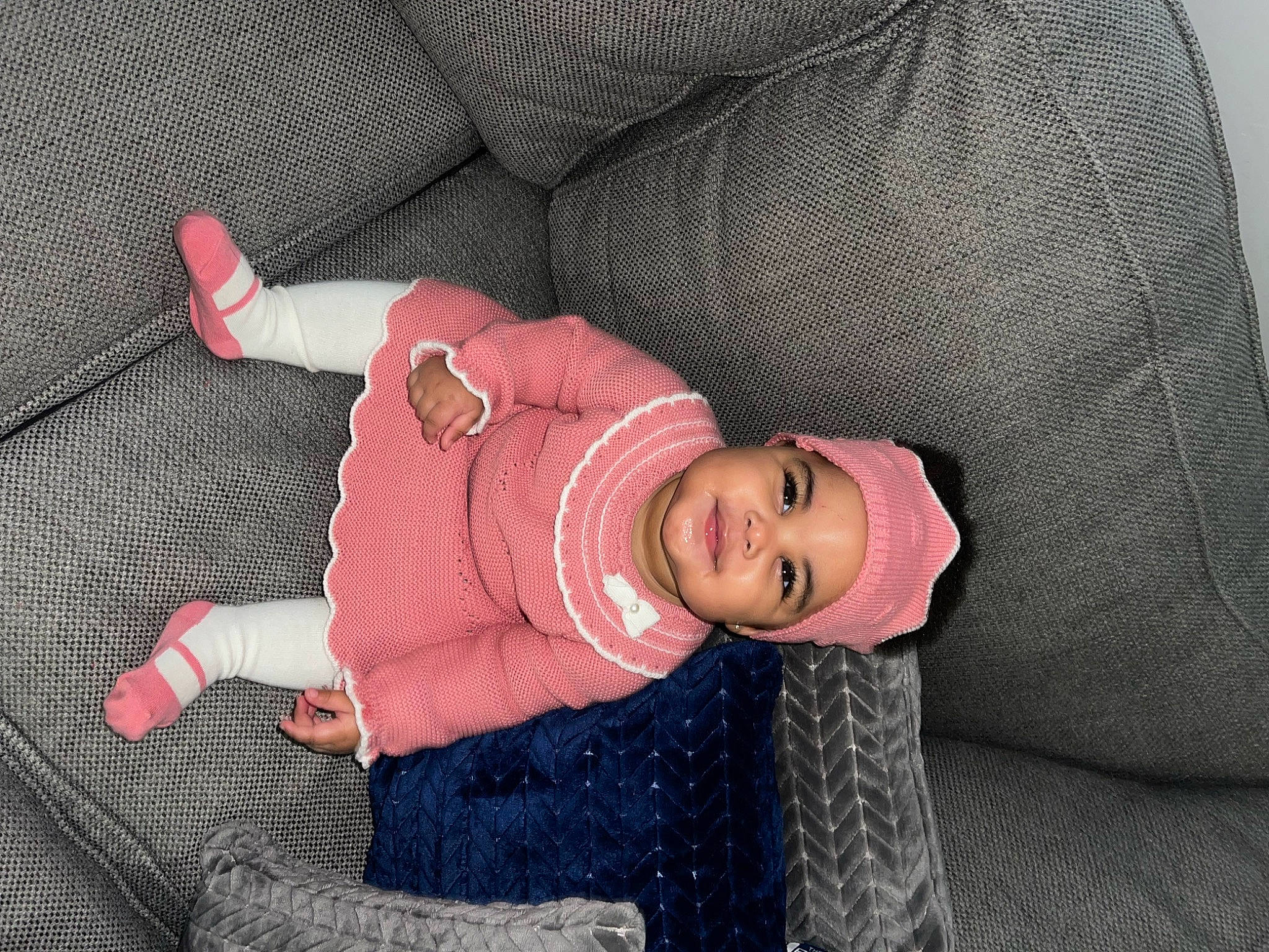 Nariah is registered to the contest to win money with this photo: baby, baby_products, baby_toddler_clothing, cheek, child, comfort, glasses, hat, headwear, joy, knee, lap, magenta, pattern, person, room, sitting, sleeve, smile, sock