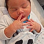 baby, newborn, sleeping, infant, panda_outfit, hand, face, clothing, blanket, cute, soft, peaceful, child, indoors, closeup, resting, skin, person, small_fingers, cozy