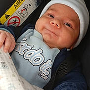 Wajdi participe au concours pour gagner de l'argent avec cette photo : baby, infant, car_seat, airbag_sign, hand, clothing, hat, blanket, person, face, skin, safety, child, cute, newborn, holding_hands, seatbelt, blue, smile, indoors