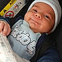 baby, infant, car_seat, airbag_sign, hand, clothing, hat, blanket, person, face, skin, safety, child, cute, newborn, holding_hands, seatbelt, blue, smile, indoors