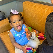 Liliana is registered to the contest to win money with this photo: toddler, child, toy, couch, indoor, playful, blue_shirt, person, smile, tongue_out, hair_bow, earrings, plastic_toys, casual, home, carpet, trash_can, happy, family, fun