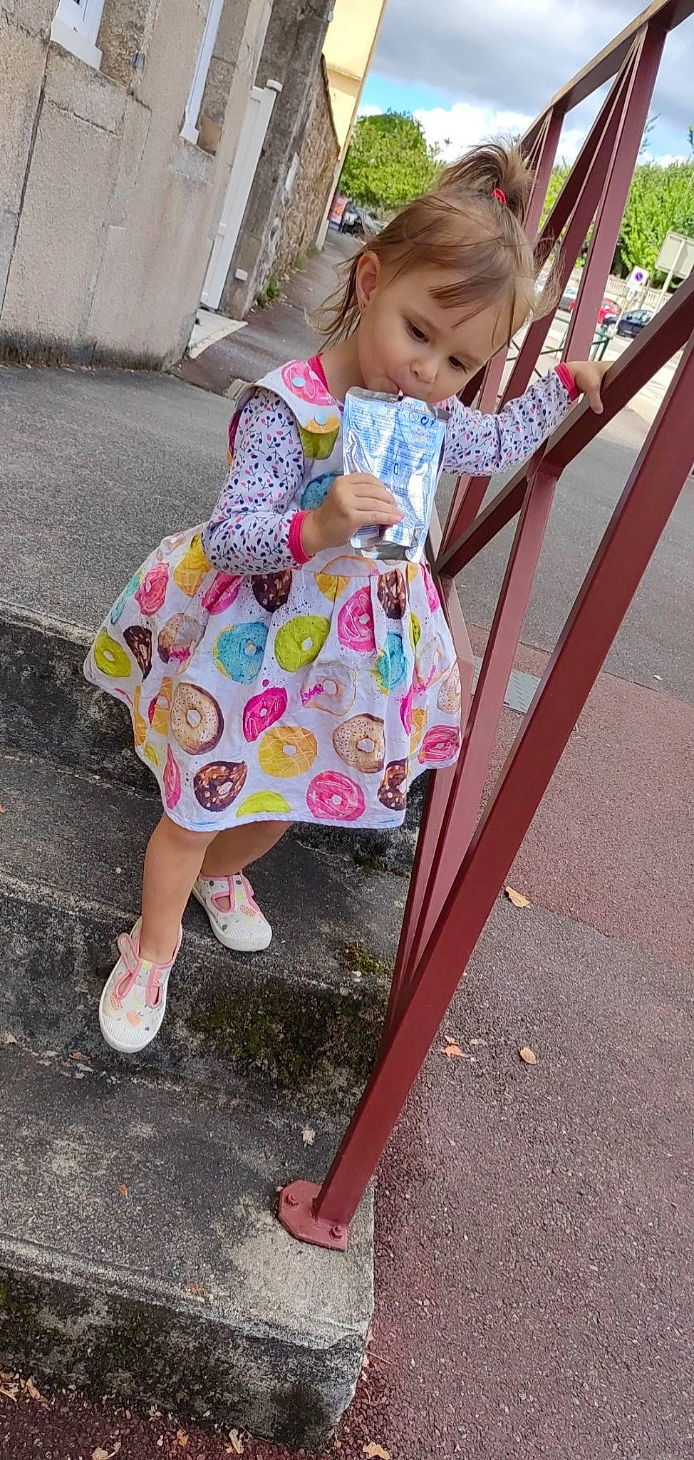 Evy participe au concours pour gagner de l'argent avec cette photo : baby_toddler_clothing, chair, child, city, dress, facial_expression, foot, fun, grass, happy, human_leg, leisure, magenta, pattern, person, pink, plant, public_space, sandal, sitting