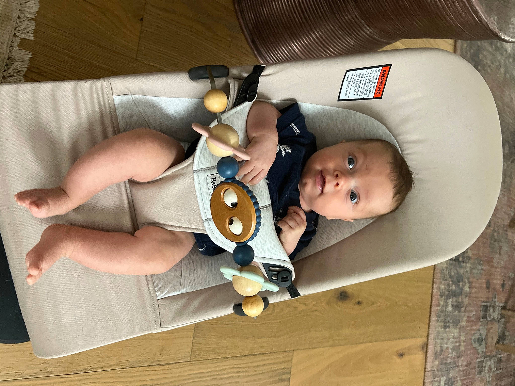 Banks is registered to the contest to win money with this photo: baby, baby_carriage, baby_products, baby_safety, baby_toddler_clothing, car_seat, chest, child, comfort, human_leg, knee, person, personal_protective_equipment, room, sitting, thigh, toddler, wood, wrist