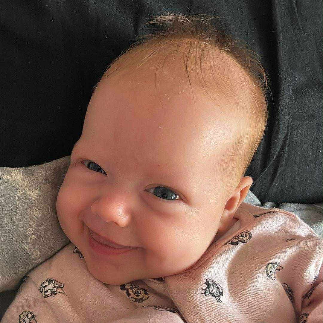 Maddison joined the competition — help win amazing prizes! baby, baby_clothes, blanket, cartoon_print, child, clothing, cute, face, happy, head, human, indoors, infant, lying_down, pink_outfit, portrait, skin, smile, soft, young_child