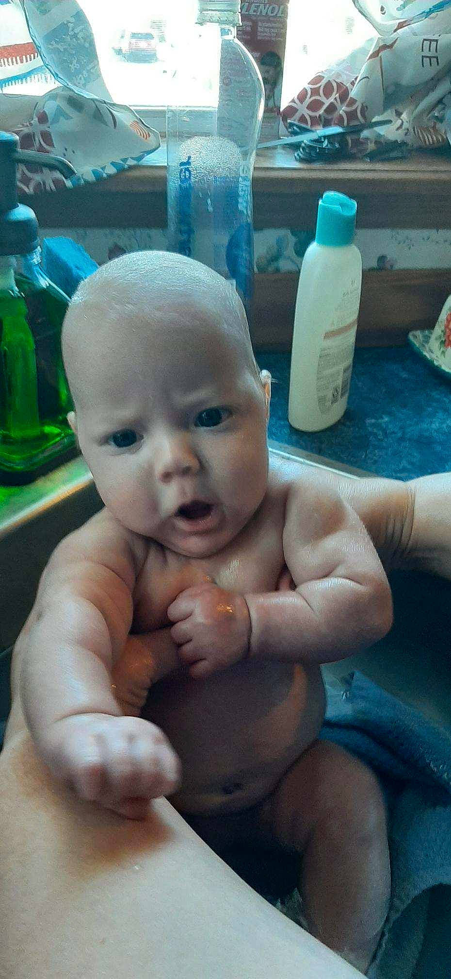 Sadie is registered to the contest to win money with this photo: arm, baby, bottle, chest, eye, finger, gesture, hand, human, joint, leg, mouth, muscle, nose, organ, person, plastic_bottle, product, skin, summer